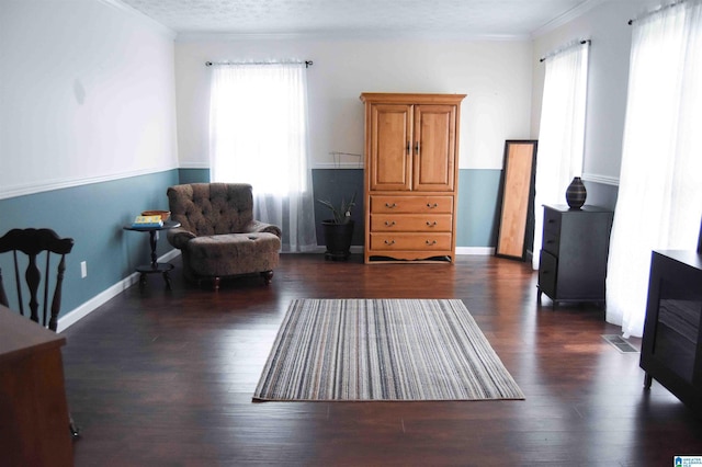 living area with a textured ceiling, dark wood finished floors, visible vents, and baseboards