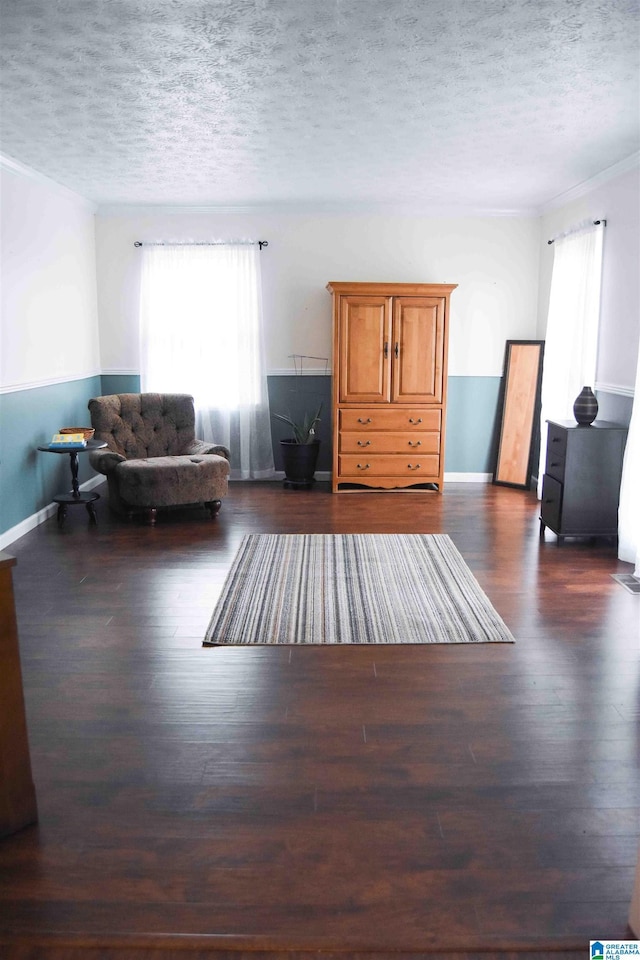 unfurnished living room featuring baseboards, dark wood finished floors, and a textured ceiling