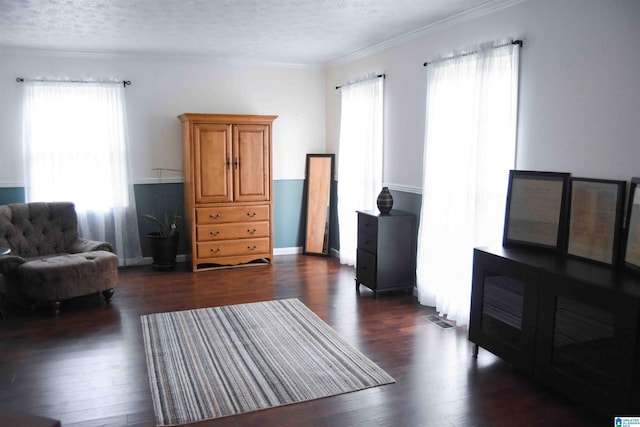 living area featuring crown molding, dark wood-style flooring, and a textured ceiling