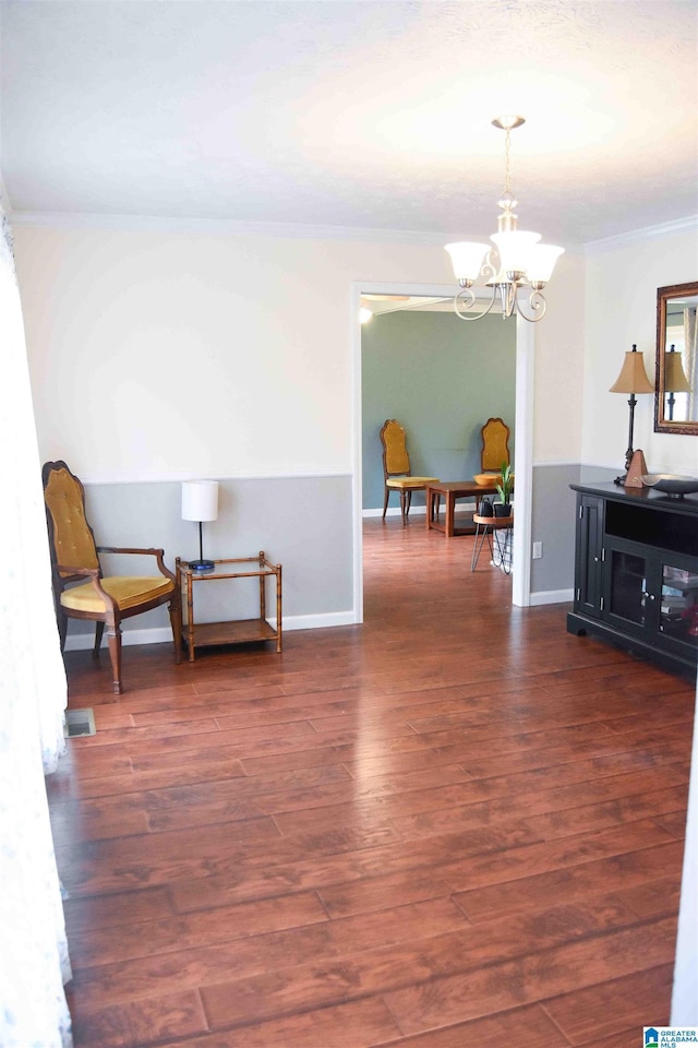 sitting room featuring baseboards, visible vents, dark wood finished floors, an inviting chandelier, and crown molding