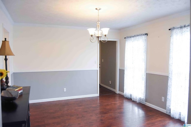 unfurnished room featuring a chandelier, dark wood-style flooring, and baseboards