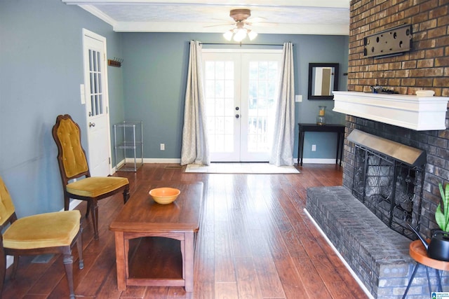 living room featuring french doors, crown molding, a fireplace, dark wood finished floors, and baseboards