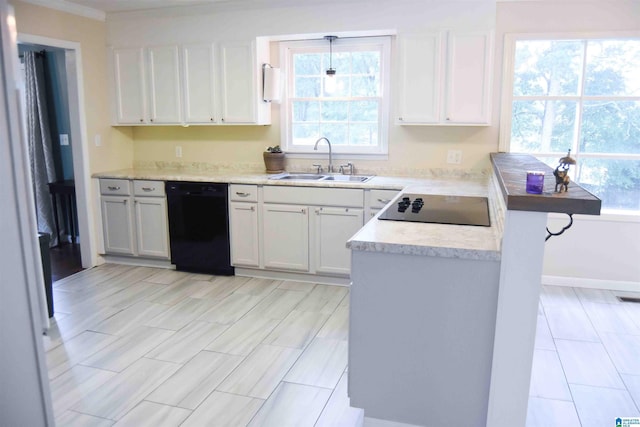 kitchen featuring light countertops, a sink, black appliances, and white cabinetry