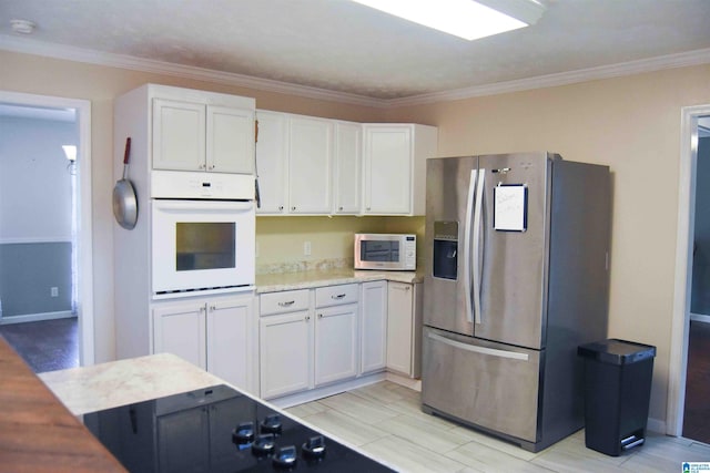 kitchen featuring light countertops, white oven, stainless steel fridge, and white cabinetry