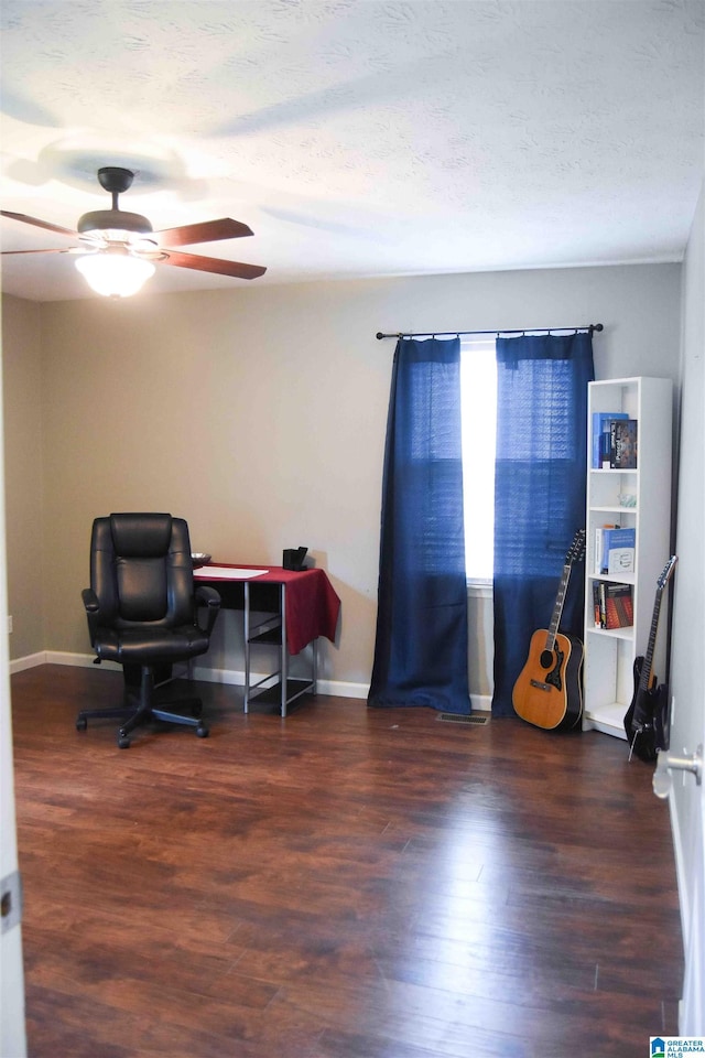 office space with dark wood-type flooring, ceiling fan, a textured ceiling, and baseboards