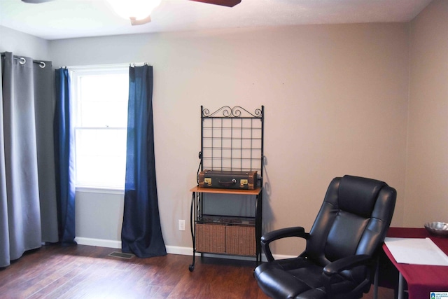 living area with ceiling fan, dark wood-type flooring, visible vents, and baseboards