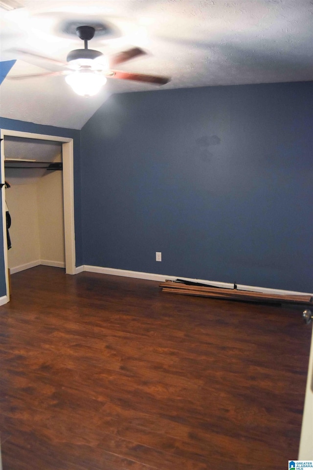 unfurnished bedroom with dark wood-style floors, a closet, ceiling fan, and baseboards