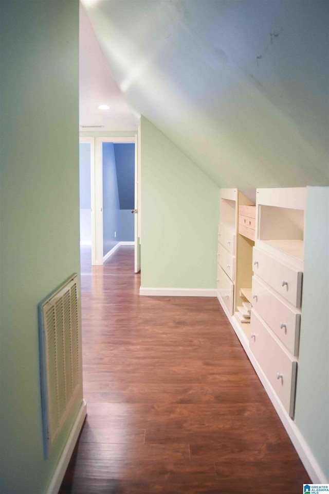 bonus room with vaulted ceiling, dark wood-type flooring, visible vents, and baseboards