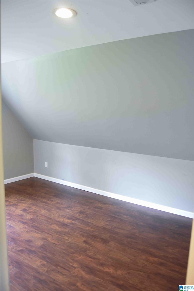 bonus room with lofted ceiling, dark wood finished floors, and baseboards