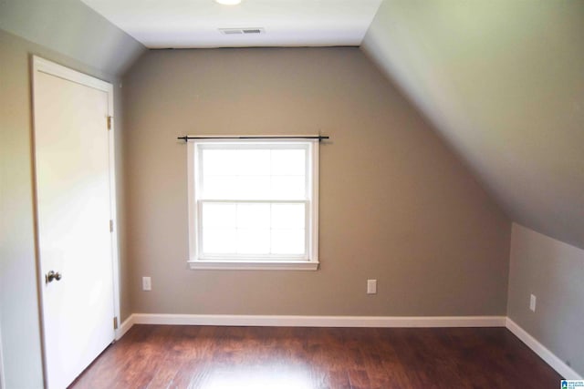 bonus room with dark wood-type flooring, visible vents, vaulted ceiling, and baseboards