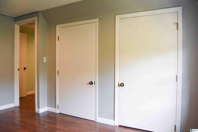 unfurnished bedroom featuring dark wood-style floors and baseboards