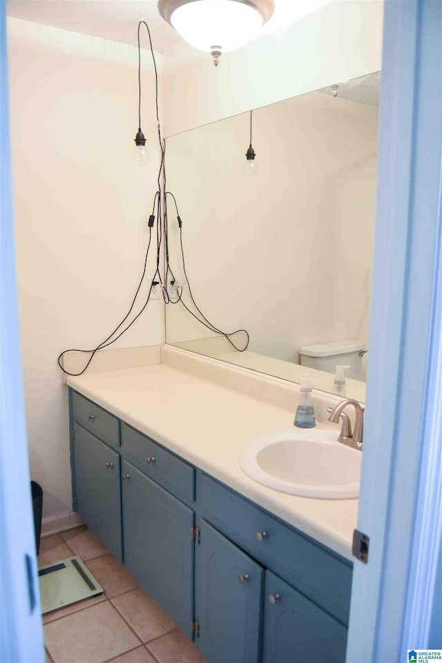 half bathroom featuring toilet, vanity, and tile patterned floors