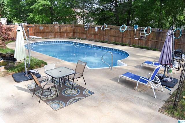 view of pool featuring a patio area, a fenced backyard, a diving board, and a fenced in pool