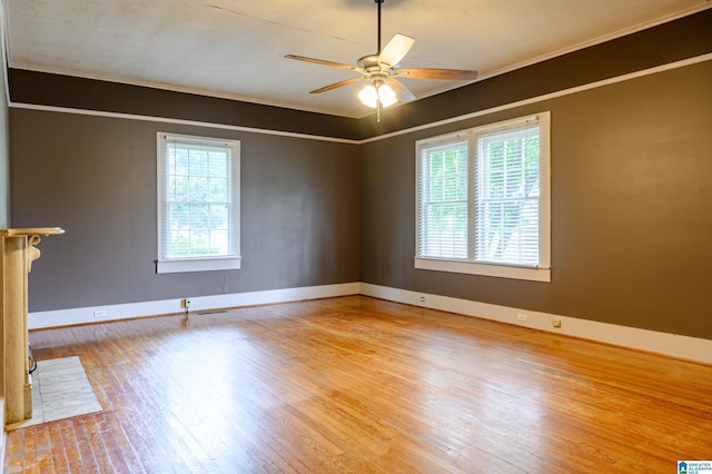 spare room featuring ceiling fan, a healthy amount of sunlight, light wood-type flooring, and crown molding