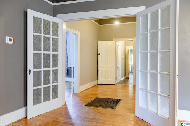 entryway featuring hardwood / wood-style flooring and crown molding