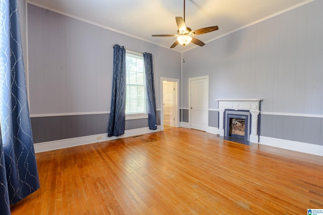 unfurnished living room with hardwood / wood-style floors, ceiling fan, and ornamental molding