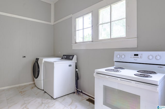 laundry room featuring washer and dryer and wood walls