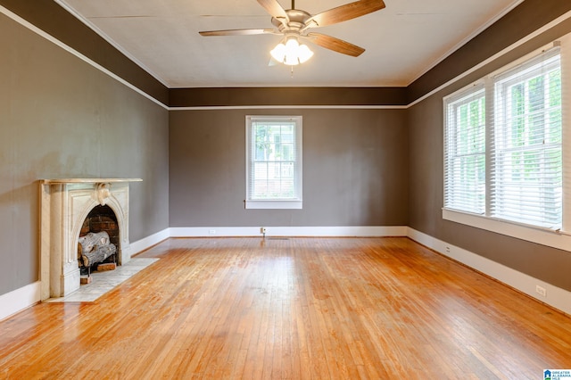 unfurnished living room featuring light hardwood / wood-style floors, ceiling fan, and crown molding