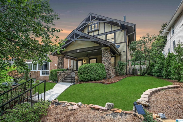 view of front of home featuring ceiling fan and a lawn