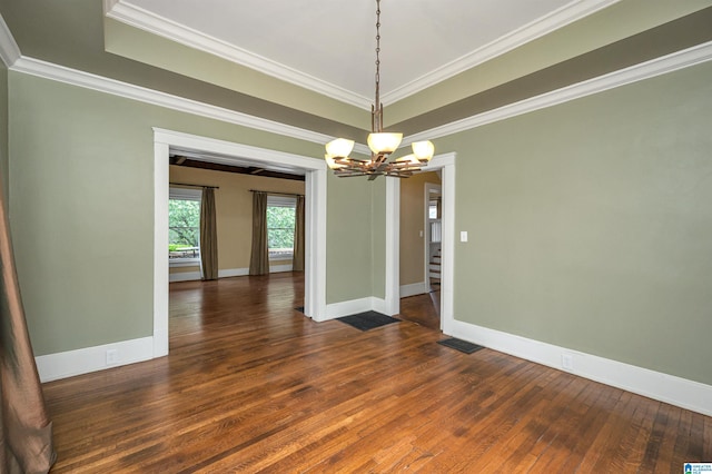 unfurnished dining area featuring dark wood-type flooring, ornamental molding, and an inviting chandelier