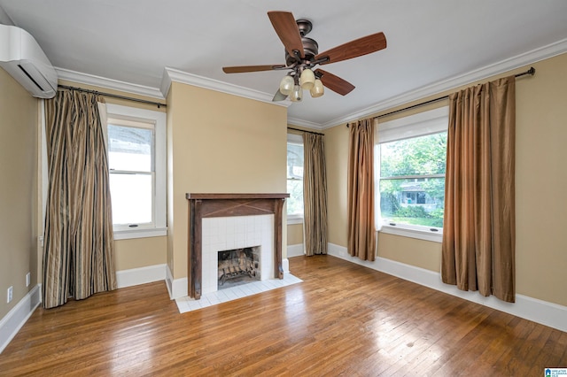 unfurnished living room featuring crown molding, a fireplace, an AC wall unit, and hardwood / wood-style flooring