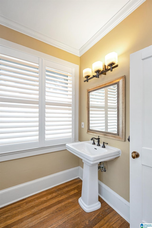 bathroom featuring hardwood / wood-style flooring, crown molding, and sink