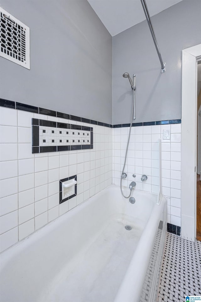 bathroom with a washtub and tile patterned floors