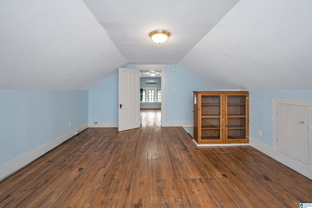 additional living space featuring vaulted ceiling and dark hardwood / wood-style flooring