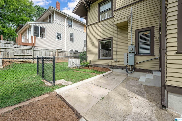 view of exterior entry featuring a yard and a patio area