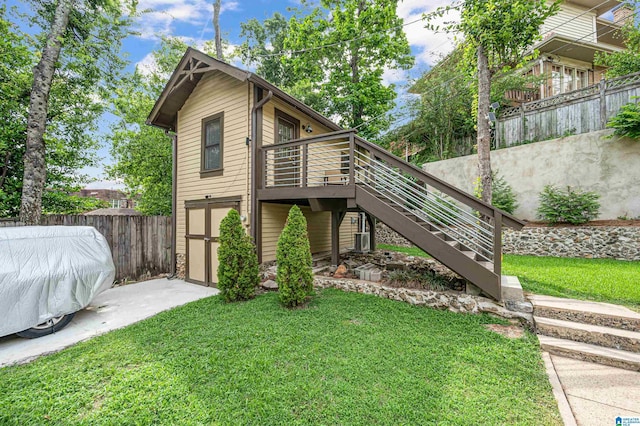 exterior space featuring a yard, a storage unit, and a deck