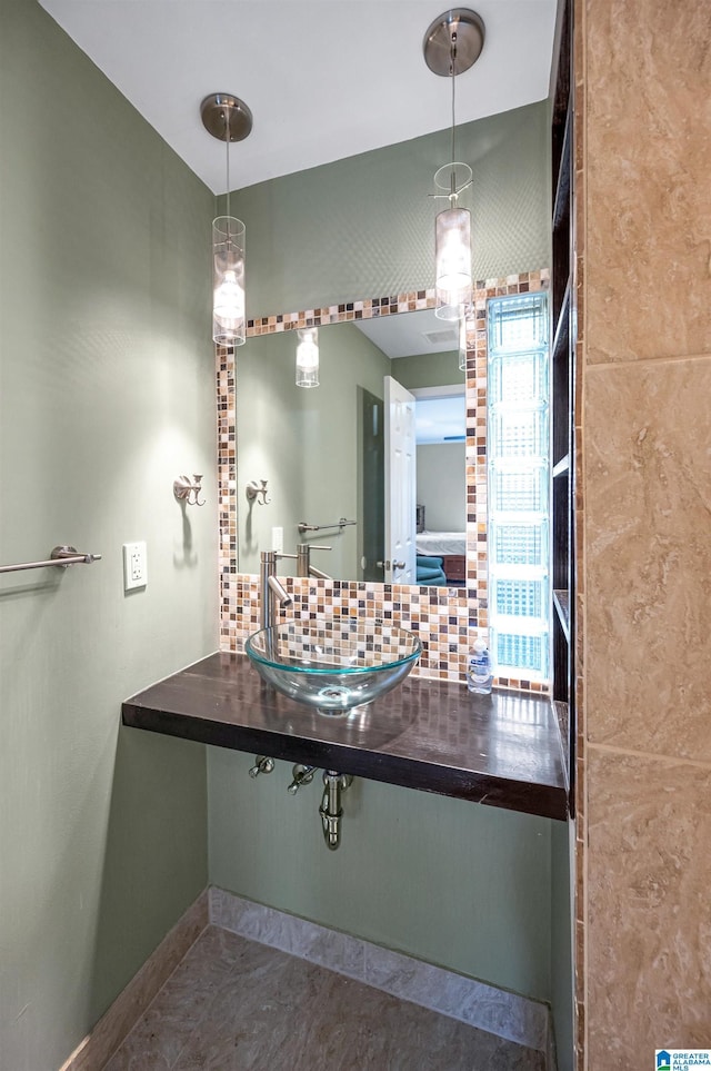 bathroom with tasteful backsplash and sink