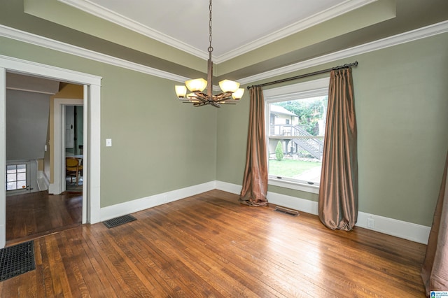 spare room featuring a notable chandelier, ornamental molding, and hardwood / wood-style floors