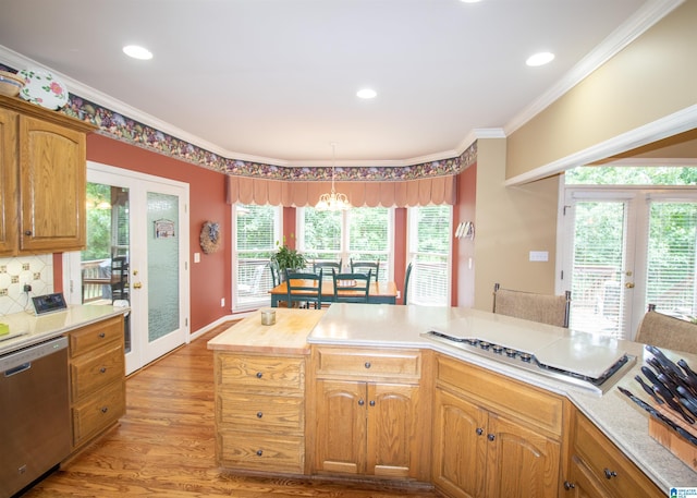 kitchen with french doors, stainless steel dishwasher, pendant lighting, light wood-type flooring, and ornamental molding