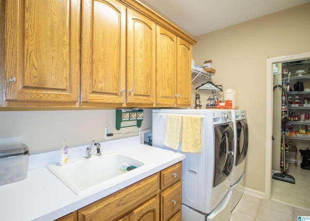 laundry area with washer and dryer, sink, light tile patterned floors, and cabinets