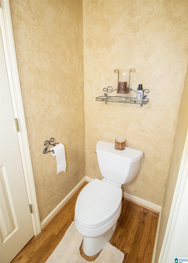 bathroom featuring wood-type flooring and toilet