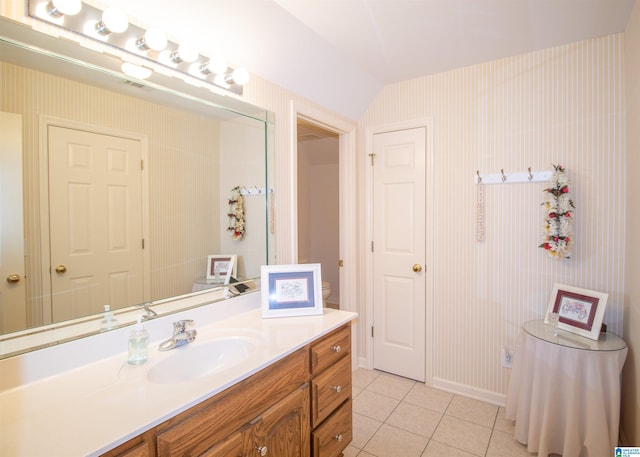 bathroom with tile patterned floors, vanity, and lofted ceiling