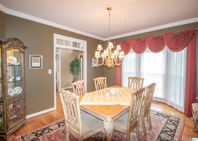 dining space with wood-type flooring, ornamental molding, and a chandelier