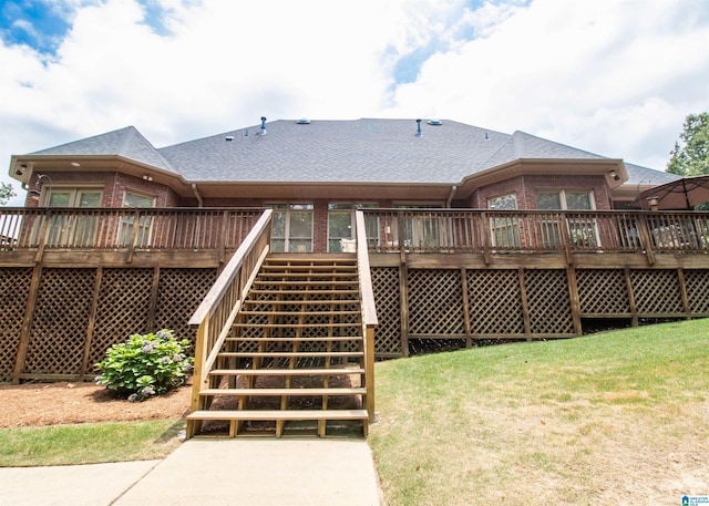 rear view of house with a yard and a wooden deck