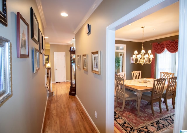 hall featuring hardwood / wood-style flooring, a chandelier, and ornamental molding