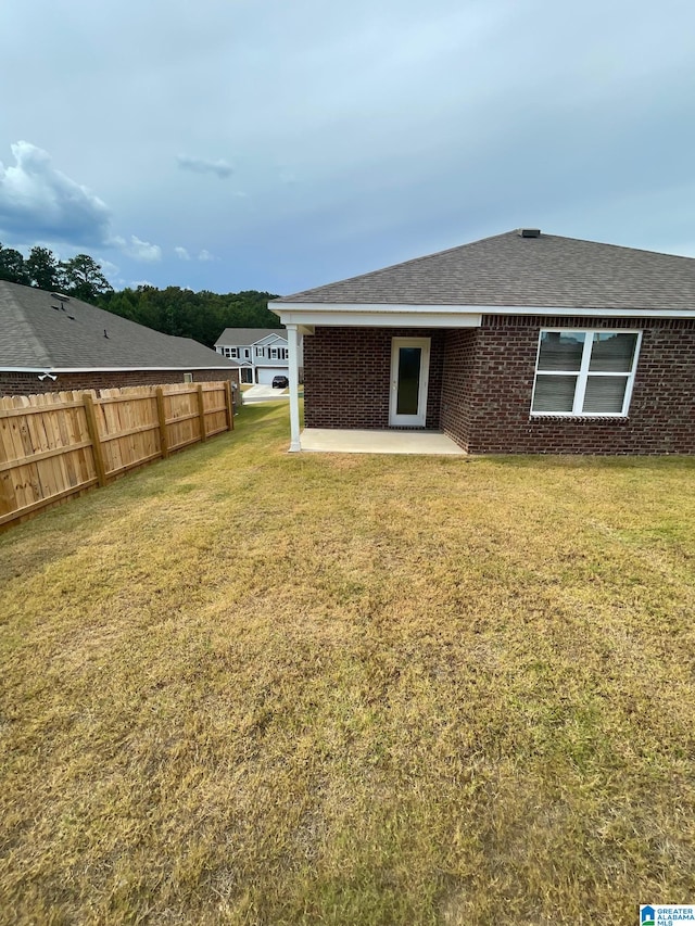 back of property featuring a yard and a patio