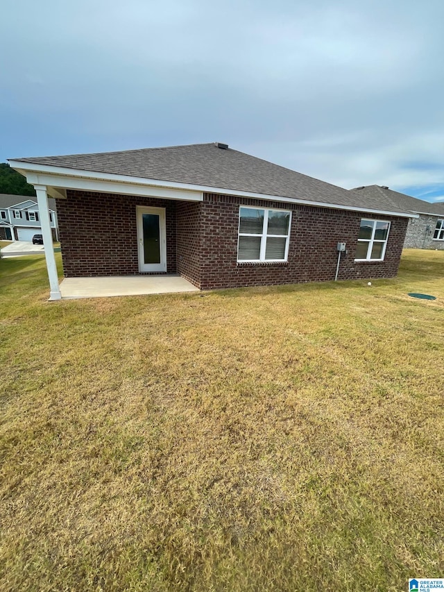 rear view of house with a lawn and a patio area