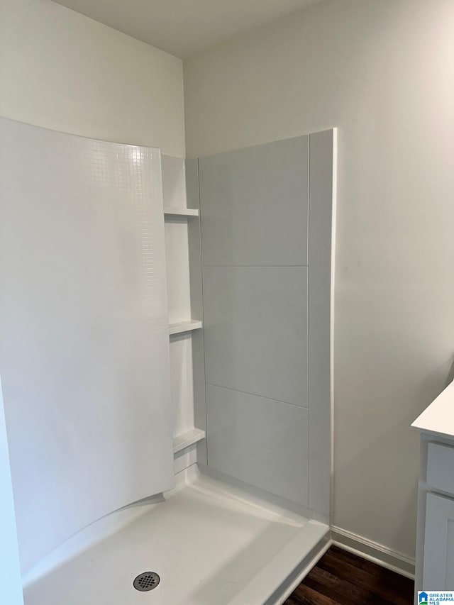 bathroom featuring wood-type flooring, walk in shower, and vanity