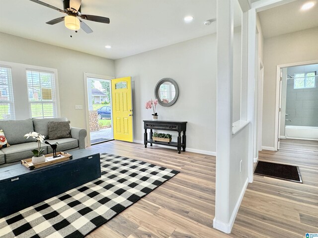 living room with light hardwood / wood-style flooring and ceiling fan