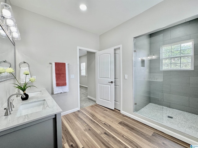 bathroom with vanity, wood-type flooring, and tiled shower