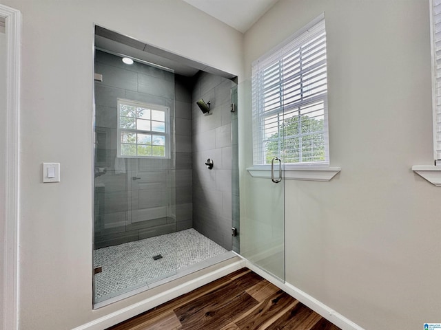 bathroom with wood-type flooring and a shower with shower door