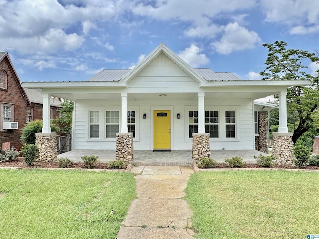 view of front of home featuring cooling unit, covered porch, and a front yard