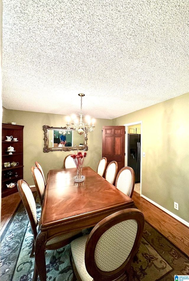 dining space with a chandelier, a textured ceiling, and wood-type flooring