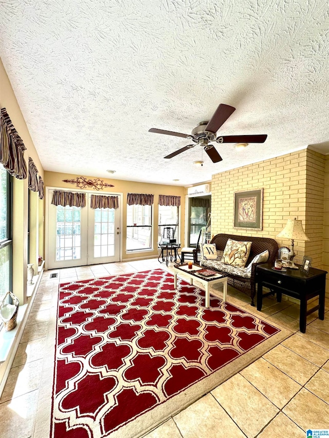 tiled living room featuring brick wall, a textured ceiling, and ceiling fan