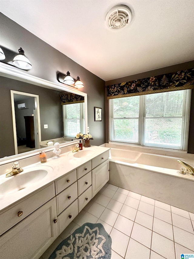 bathroom with a tub, tile patterned floors, a healthy amount of sunlight, and double vanity