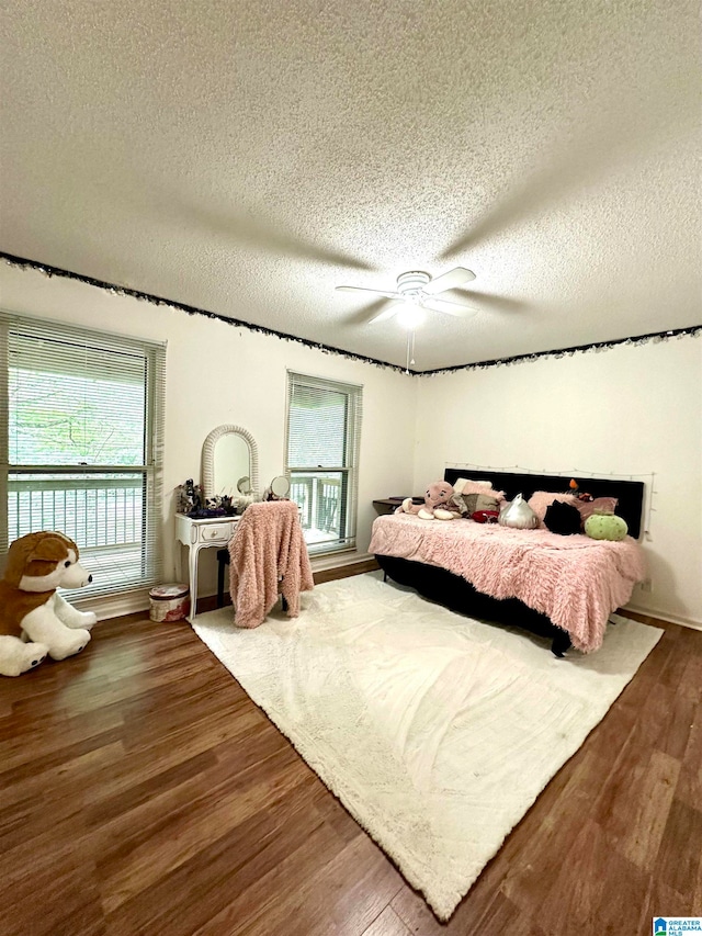 bedroom featuring ceiling fan, a textured ceiling, and hardwood / wood-style flooring